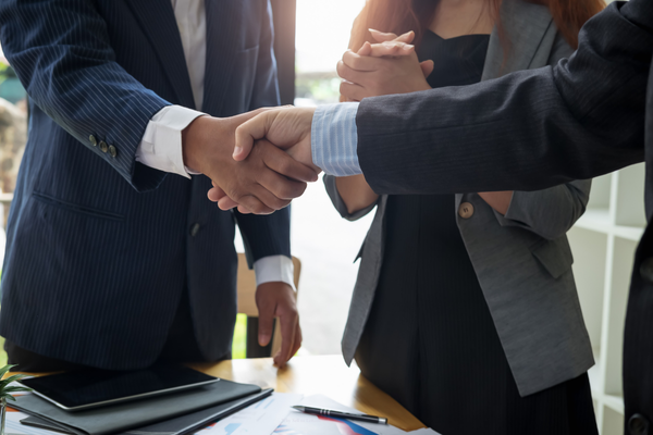 people shaking hands after selling a property